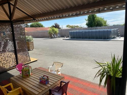 a patio with a table and chairs in a parking lot at Le gîte de Kelly in Trémont
