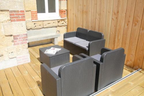 a patio with two chairs and a table and a couch at Le gîte de Kelly in Trémont