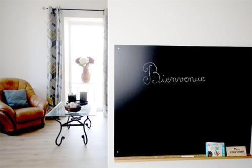 a living room with a chair and a tv at Le gîte de Kelly in Trémont
