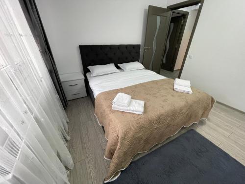 a bedroom with a bed with two towels on it at Traveler’s Home in Suceava