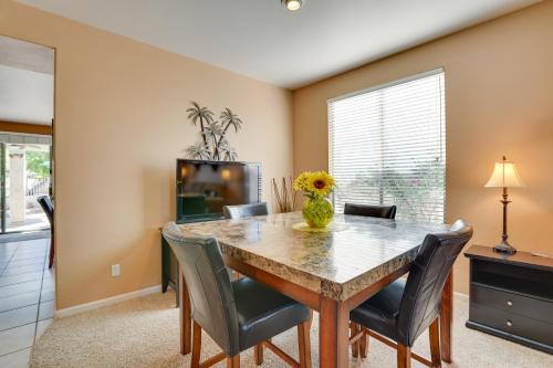a dining room with a table and chairs and a television at 5 Mi to State Farm Stadium Home with Private Pool! in Avondale