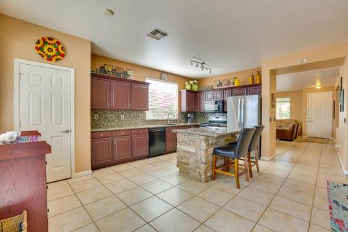 a large kitchen with brown cabinets and a refrigerator at 5 Mi to State Farm Stadium Home with Private Pool! in Avondale