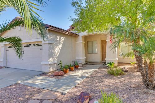 a house with a garage and a palm tree at 5 Mi to State Farm Stadium Home with Private Pool! in Avondale