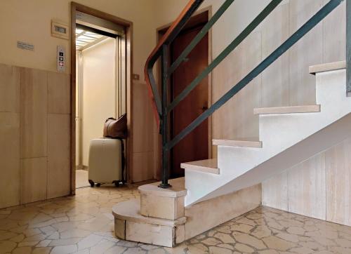 un pasillo con una escalera y una maleta en Corte Melone room rental, en Verona