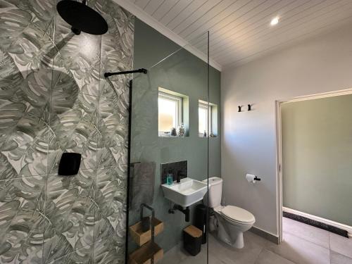 a bathroom with a shower and a toilet and a sink at Sea-esta in Plettenberg Bay