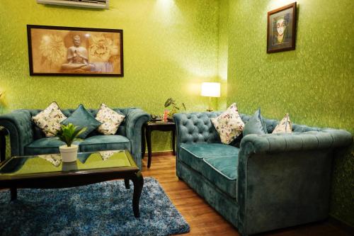 a living room with two blue couches and a table at The Vaishnavi in Deoghar