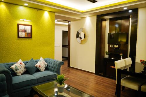 a living room with a blue couch and a television at The Vaishnavi in Deoghar