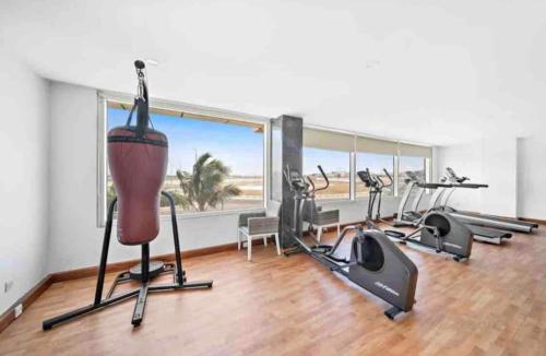 a gym with cardio equipment and a large window at Obhur Residence 2 in Obhor