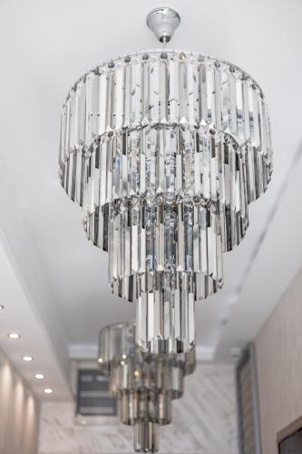 a large silver chandelier hanging from a ceiling at ForS Konak Apartments in Belgrade