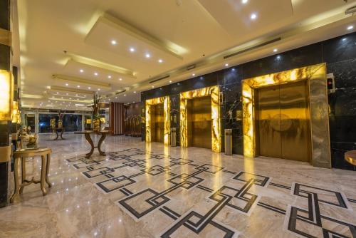 ジッダにあるParadise Inn Jeddah Hotelの金と黒の壁と大理石の床が特徴のロビー