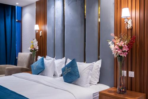 a bedroom with a bed with blue and white pillows at Paradise Inn Jeddah Hotel in Jeddah