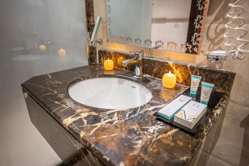 a bathroom sink with two candles and a mirror at Paradise Inn Jeddah Hotel in Jeddah