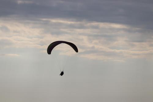 een persoon die met een parachute in de lucht vliegt bij Hobbit House Bir in Bir