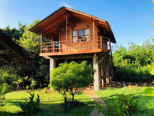 a tree house in the middle of a field at Sungreen Cottage Sigiriya in Sigiriya