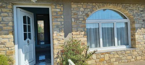 een stenen huis met een deur en een raam bij Casa Bia Mara IUN SU172600 in Villanovaforru