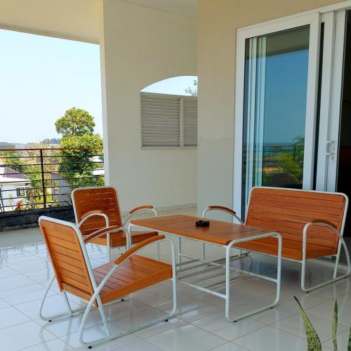 a table and chairs on a balcony with a view at Garden House Jepara in Jepara