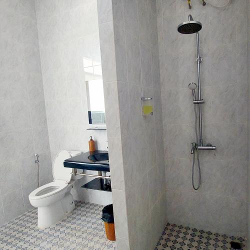 a bathroom with a shower with a toilet and a sink at Garden House Jepara in Jepara