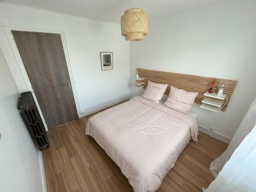 a bedroom with a bed with white sheets and pillows at GÎTES Maisons de Champagnes in Reims