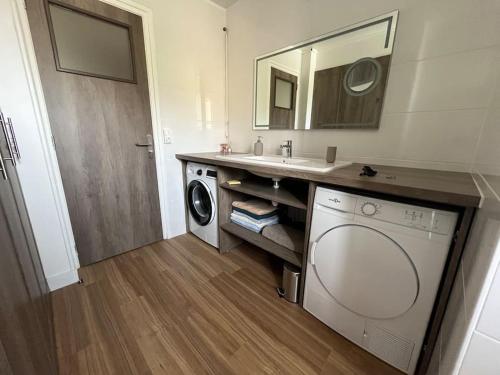uma casa de banho com uma máquina de lavar roupa e um lavatório em GÎTES Maisons de Champagnes em Reims