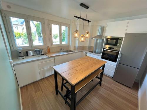 une cuisine avec une table en bois et un réfrigérateur dans l'établissement GÎTES Maisons de Champagnes, à Reims