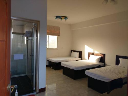 a room with two beds and a glass shower at 好宿民宿 in Jinning