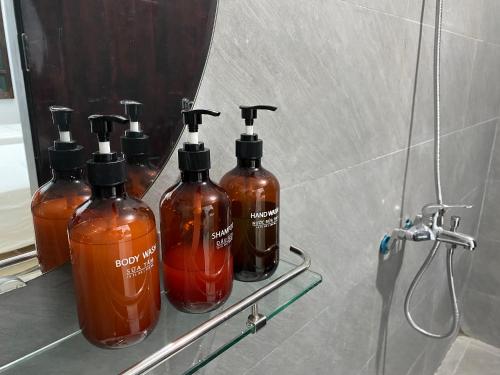 4 butelki mydła na półce w łazience w obiekcie Hanoi AVANA HOMESTAY LONG BIEN w mieście Hanoi