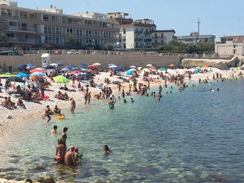 a crowd of people on a beach with umbrellas at Casa Anseramo in Bisceglie
