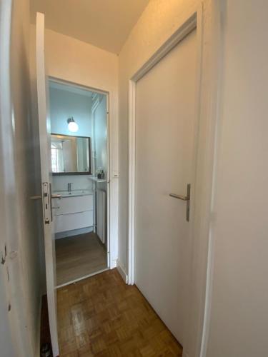 un corridoio con porta che conduce al bagno di Chambre chez l’habitant près de Tour Eiffel a Parigi