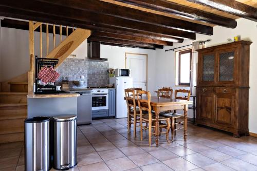 le verger في Saint-Marcel: مطبخ مع طاولة وكراسي في غرفة