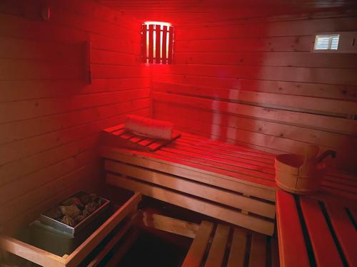 una habitación roja con un banco en una sauna en La Maison des Rêves - Bran, en Bran