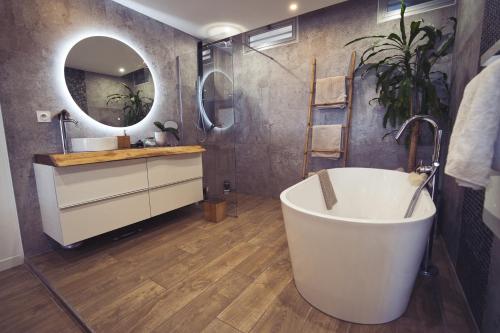 une salle de bain avec une baignoire, un lavabo et un miroir dans l'établissement Villa vue Mer panoramique, Plage 10min, Piscine, Tennis, Pétanque, à Vallauris