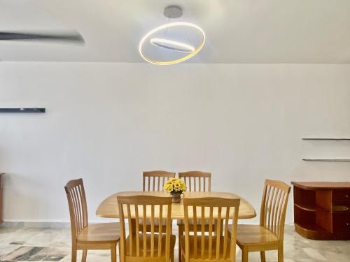 a dining room with a wooden table and chairs at BayView Suites Port Dickson By MAISON in Port Dickson