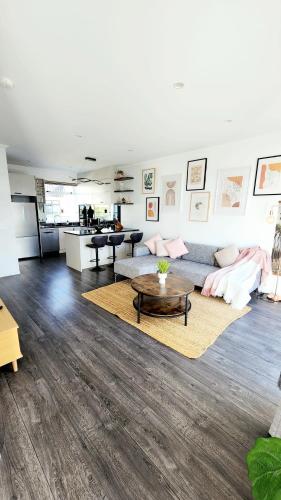 een woonkamer met een bank en een tafel bij Plush 3 bedroom property in Hobsonville in Auckland