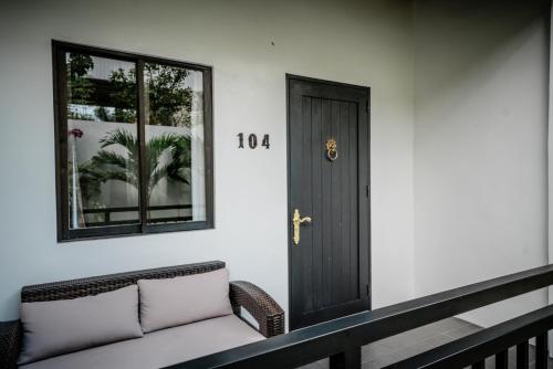 a porch with a black door and a couch at Tana Mysterious garden in Panglao