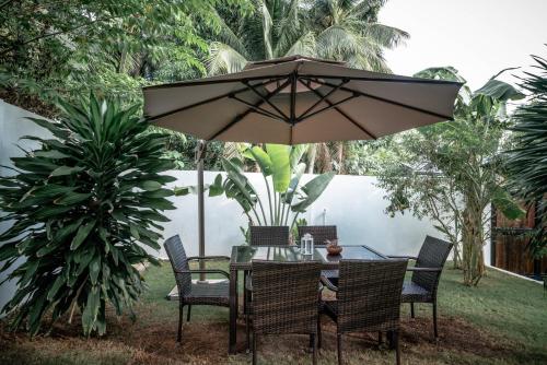 a table and chairs under an umbrella in a yard at Tana Mysterious garden in Panglao