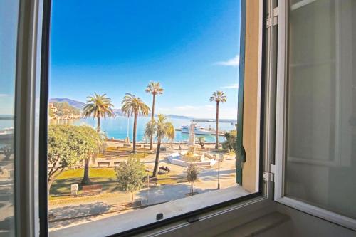 a window with a view of the ocean and palm trees at IL FARO by KlabHouse in Santa Margherita Ligure