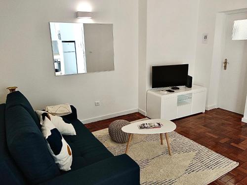 uma sala de estar com um sofá e uma televisão em Cantinho do Castelo em Brangança