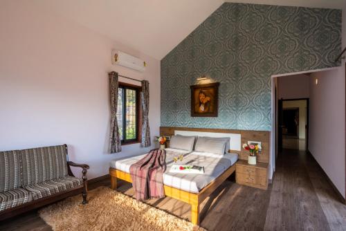 a bedroom with a bed and a couch at Courtyard Villa by Hillstaytion,com in Panchgani