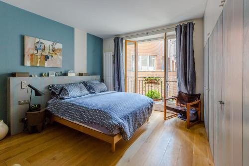 a bedroom with a bed and a large window at LOFT 11e près Canal St-Martin - Chambre climatisée SDB privée in Paris