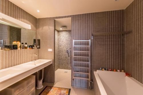 ein Bad mit einer Badewanne, einem Waschbecken und einer Dusche in der Unterkunft LOFT 11e près Canal St-Martin - Chambre climatisée SDB privée in Paris