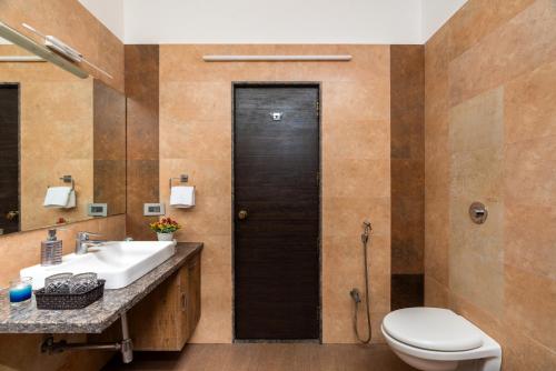 a bathroom with a toilet and a sink at Courtyard Villa by Hillstaytion,com in Panchgani