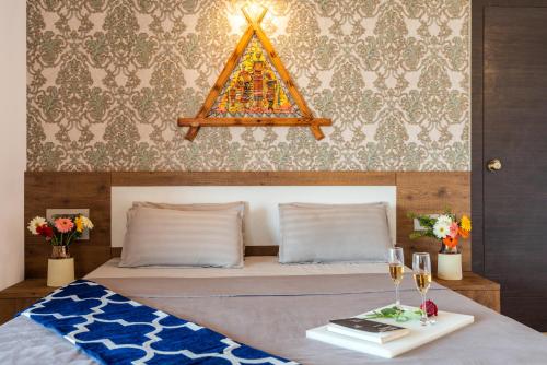 a bedroom with a bed and a table with wine glasses at Courtyard Villa by Hillstaytion,com in Panchgani