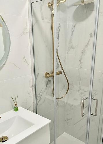 a shower with a glass door next to a sink at Cantinho do Castelo in Bragança