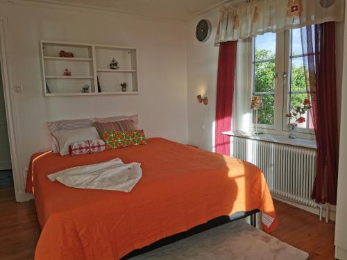 een slaapkamer met een bed met een oranje deken bij Hus nära havet in Bergkvara