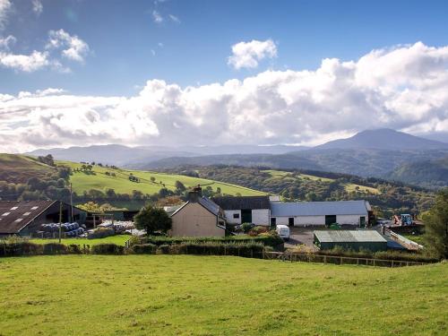 an image of a farm with mountains in the background at Siabod Huts in Betws-y-coed