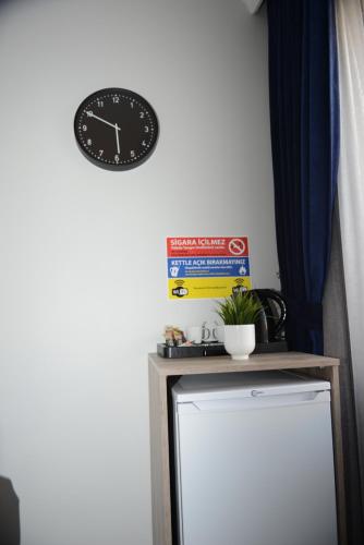 a clock on a wall above a small refrigerator at Kassimo Hotel in Istanbul