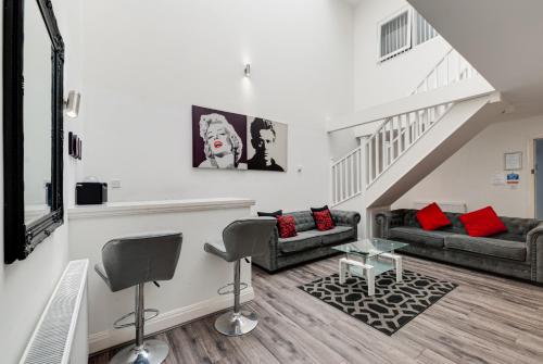 a living room with two couches and a staircase at Duke Street Apartment Hotel Liverpool City Centre in Liverpool