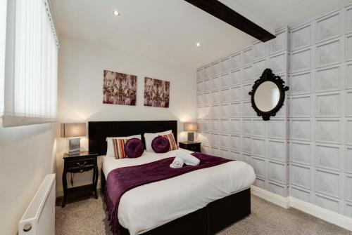 a bedroom with a large bed and a mirror at Duke Street Apartment Hotel Liverpool City Centre in Liverpool