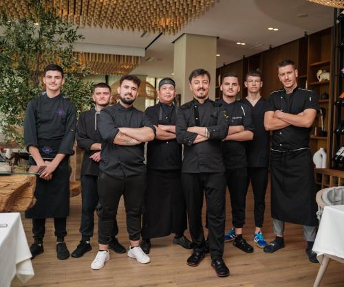 a group of men in black uniforms posing for a picture at Supreme Hotel in Golem