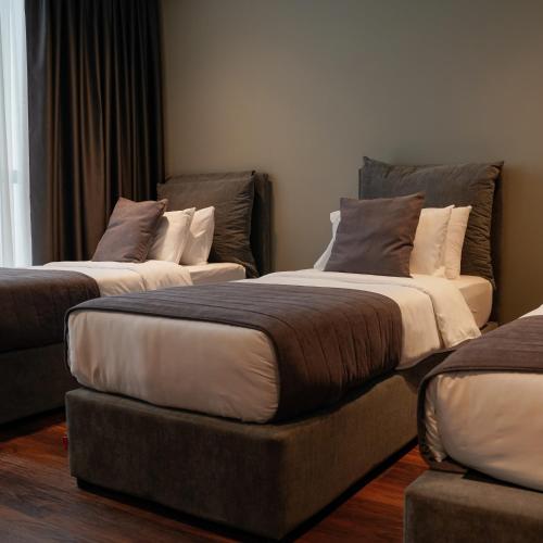 a room with three beds and a ottoman at Supreme Hotel in Golem